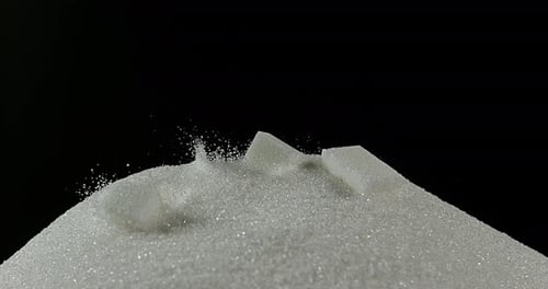 White Sugar Cubes falling against Black Background, Slow Motion 4K