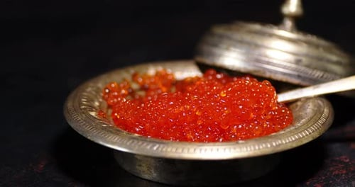 A Plate of Red Caviar Slowly Rotates on the Table.