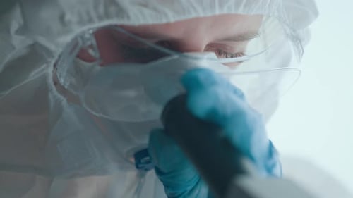 Scientist Working with Microscope in Modern Lab