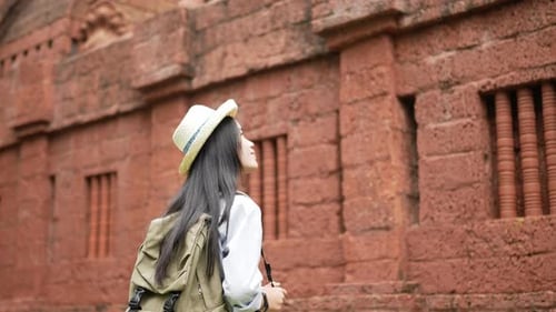 Woman visiting and taking a photo ancient temple