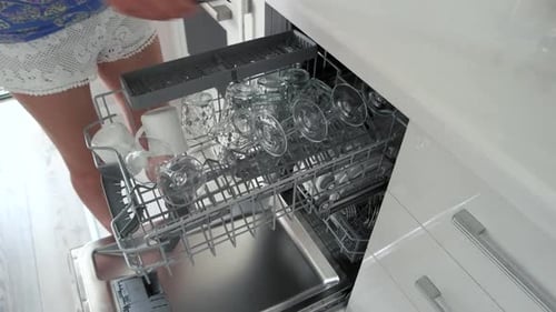 Woman Taking Out Glasses and Cups From Dishwasher