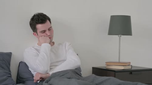 Man Taking Nap While Sitting in Bed