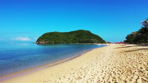 Lebendige Farben eines exotischen Strandes mit weißem Sand, der von ruhigem, klarem Wasser aus blauem Meer und grünem Hügel umspült wird