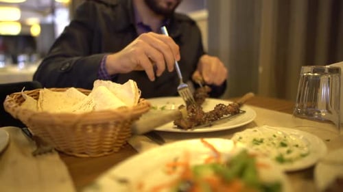 Man Eating Skewer with Flatbread at Restaurant