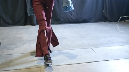 Female Model in Ripped Red Jeans and Heavy Boots Walks on Podium Catwalk Runway