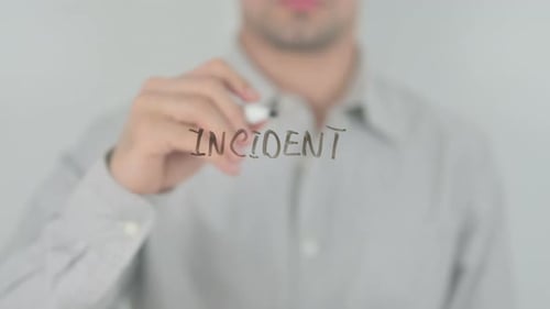 Man Writing the Word 'Incident' on Glass