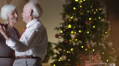 Elderly Couple Dancing Next to Christmas Tree