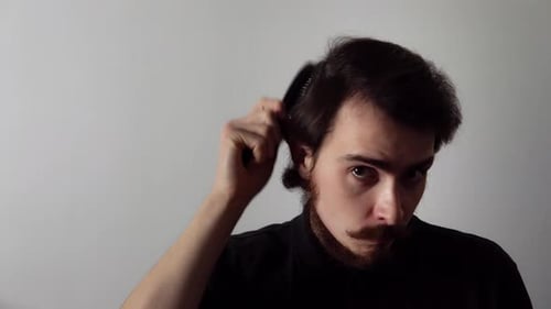 Man Grooming Hair and Beard with Brush