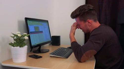 Stressed Man Working At Office Desk