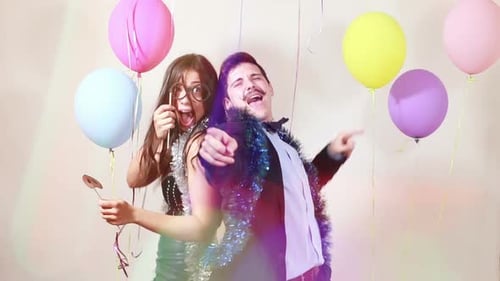 Happy crazy couple enjoying dancing in photo booth