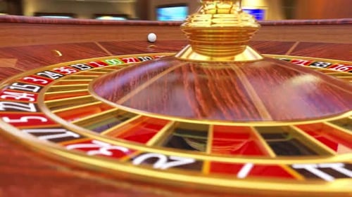 Roulette ball is rolling on the roulette wheel and gamblers bet for black or red