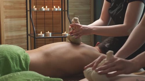 Receiving a Herbal Compress Massage in Spa Setting
