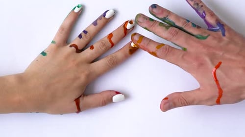 Creative Concept Man and Woman Make Prints of Their Painted Hands on a White Background