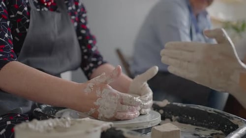 Hands Shape Clay on Pottery Wheel in Studio