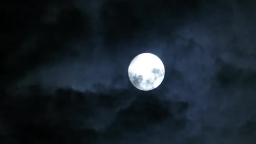 Full Moon Moving Between Clouds
