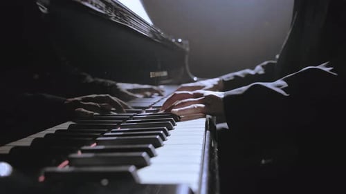 Hands playing a Piano at Night