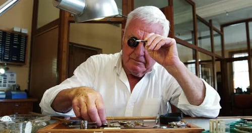 Senior Man Repairing Watches at His Workbench
