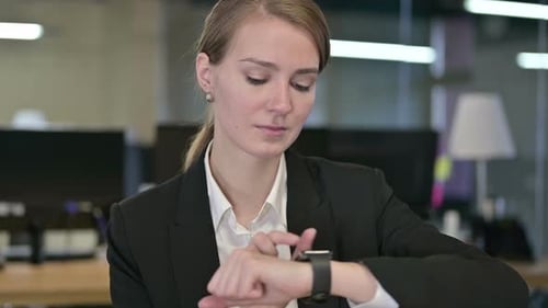 Woman Uses Smart Watch in Modern Office Setting