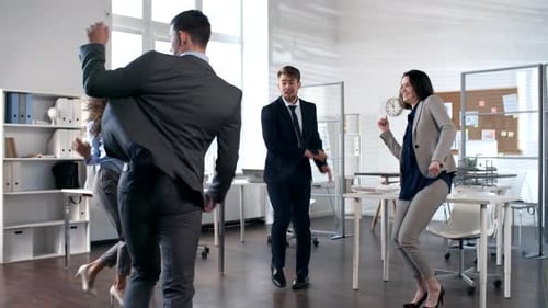 Homme d'affaires faisant le stand tout en dansant avec des collègues au bureau
