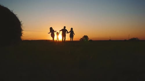 Family Runs Hand in Hand During Sunset