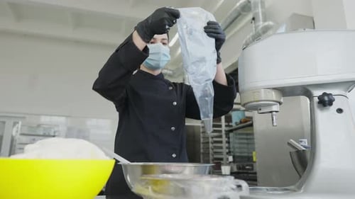 Woman Fills Pastry Bag in Commercial Kitchen
