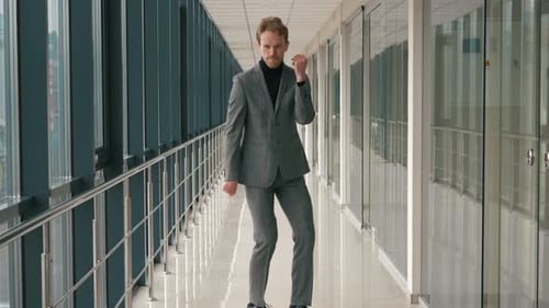 Happy Successful Businessman Dancing In a Crazy Way at indoor modern office building. Funny dance of