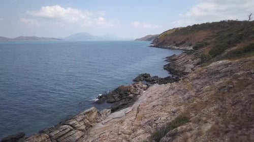 Aerial: a beautiful low altittude lansdcape view of a tropical island a rocky beach with stones layi