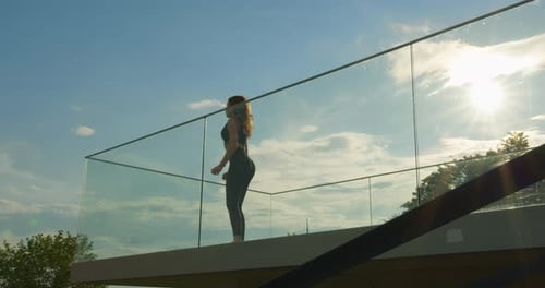 Fit Woman Doing Squats on Urban Balcony