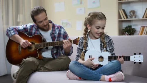 Child and Man Playing Musical Instruments at Home