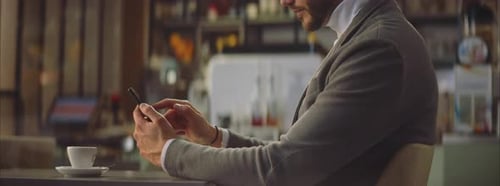 Man sitting in cafe and texting