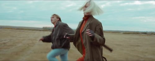 Happy Couple Running Together through Autumn Field