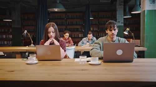 Focused Millennial Students of International University Studying Remotely at Library