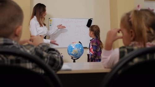 Closeup of Teacher Working with Children in a Classroom in an Elementary School