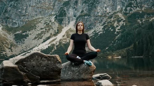 Beautiful and Healthy Young Woman Meditates on a Mountain Lake, Practicing Yoga, Enjoys the