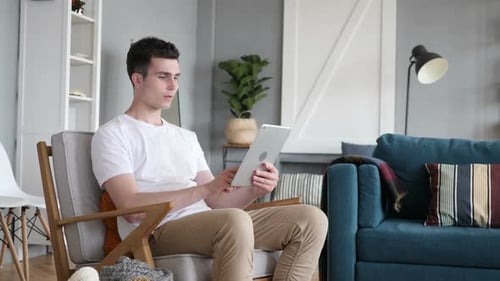 Man Reacts to Tablet Screen in Modern Living Room