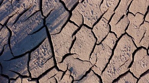 Looking down at the cracked surface of a dry river