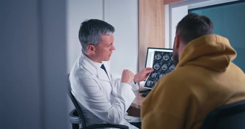 Doctor Discusses X-Ray with Patient in Clinic