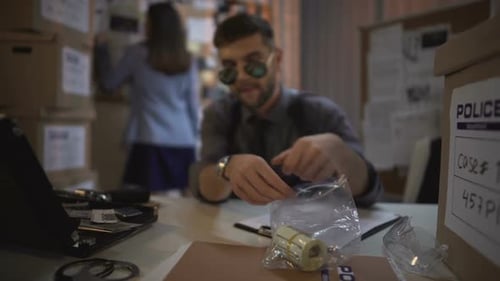 Detective Examines Evidence in Cluttered Police Office