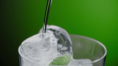 Liquid Being Poured Over Ice and Mint