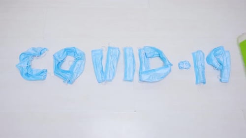 Used Medical Masks on the Floor Wiped with a Mop. Cleaning of Disposable Masks in Public Places