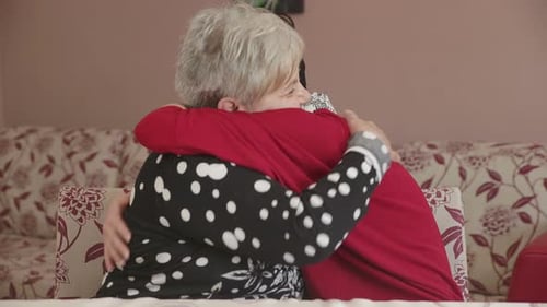 Heartwarming Embrace Between Senior Woman and Young Adult