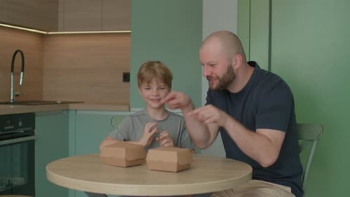 Dad and Son Eating Burgers Together at Home