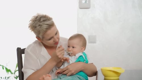 Woman Feeding Baby in Bright Indoor Setting