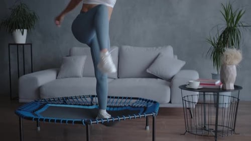 Woman Exercising on a Trampoline in Living Room
