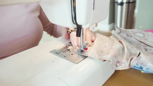 Woman Sews Fabric with a Sewing Machine