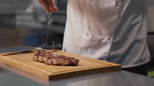 Chef Adding Salt to Cooked Steak