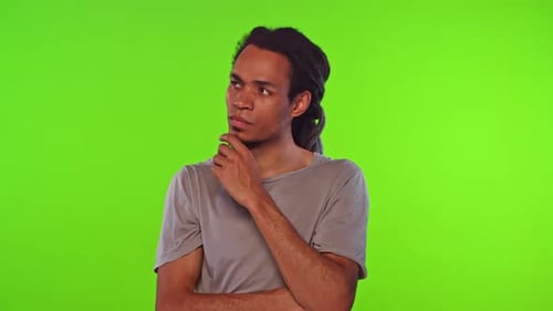 Young Man with Dreads Thinking in Front of Green Screen