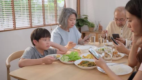 Family Eating Dinner While Using Cell Phones