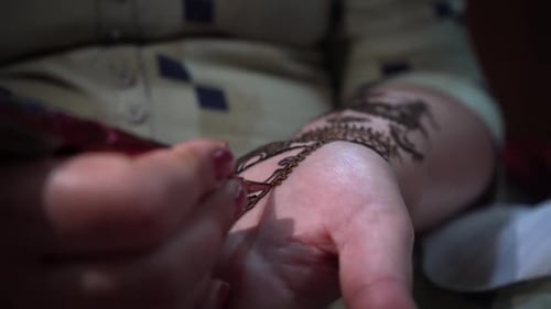 Aplicación de un tatuaje de henna en la palma de una mujer, arte decorativo tradicional indio en la ciudad de Agra, estado de Uttar