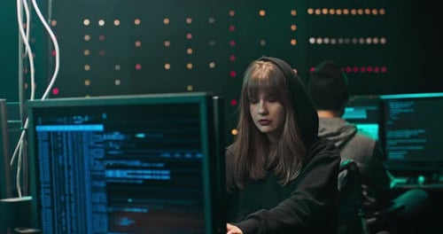 Woman Typing on Computer in Dimly Lit Room